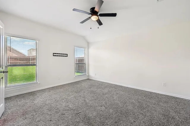 an empty room with windows and fan