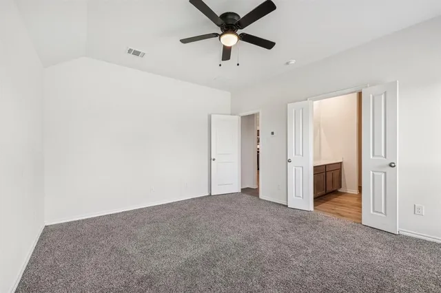 a view of empty room with ceiling fan