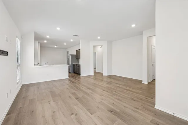 a view of an empty room with wooden floor