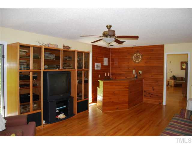 3407 West Cornwallis Road Durham, NC 27705 - Photo 6 of 12 Den right off of dining room. Wood paneled bar with natural light looking out to the backyard.