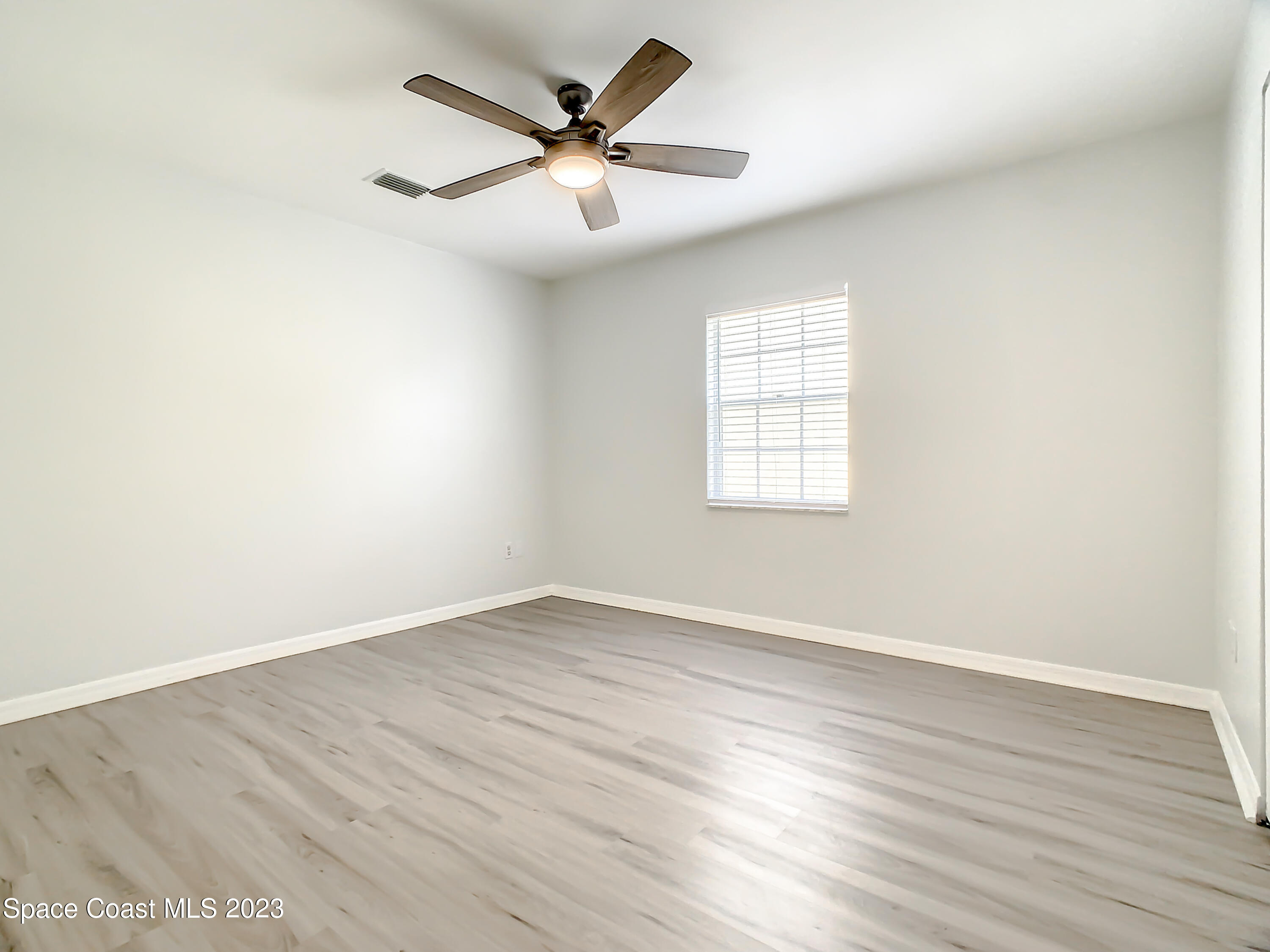 8520 Highway 1, Unit E9 Micco, FL 32976 - Photo 14 of 24 an empty room with wooden floor and windows