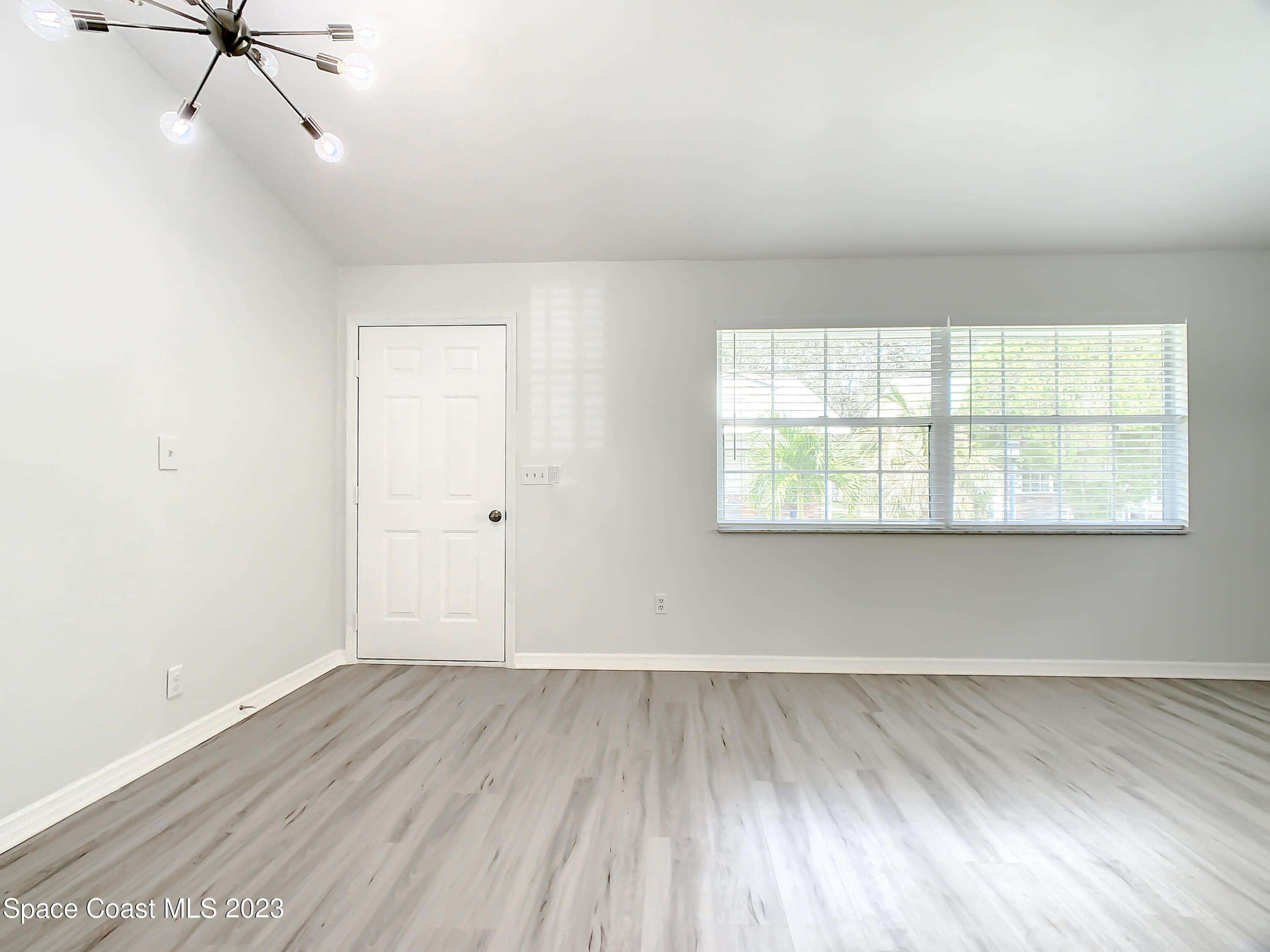 8520 Highway 1, Unit E9 Micco, FL 32976 - Photo 2 of 24 an empty room with wooden floor fan and windows