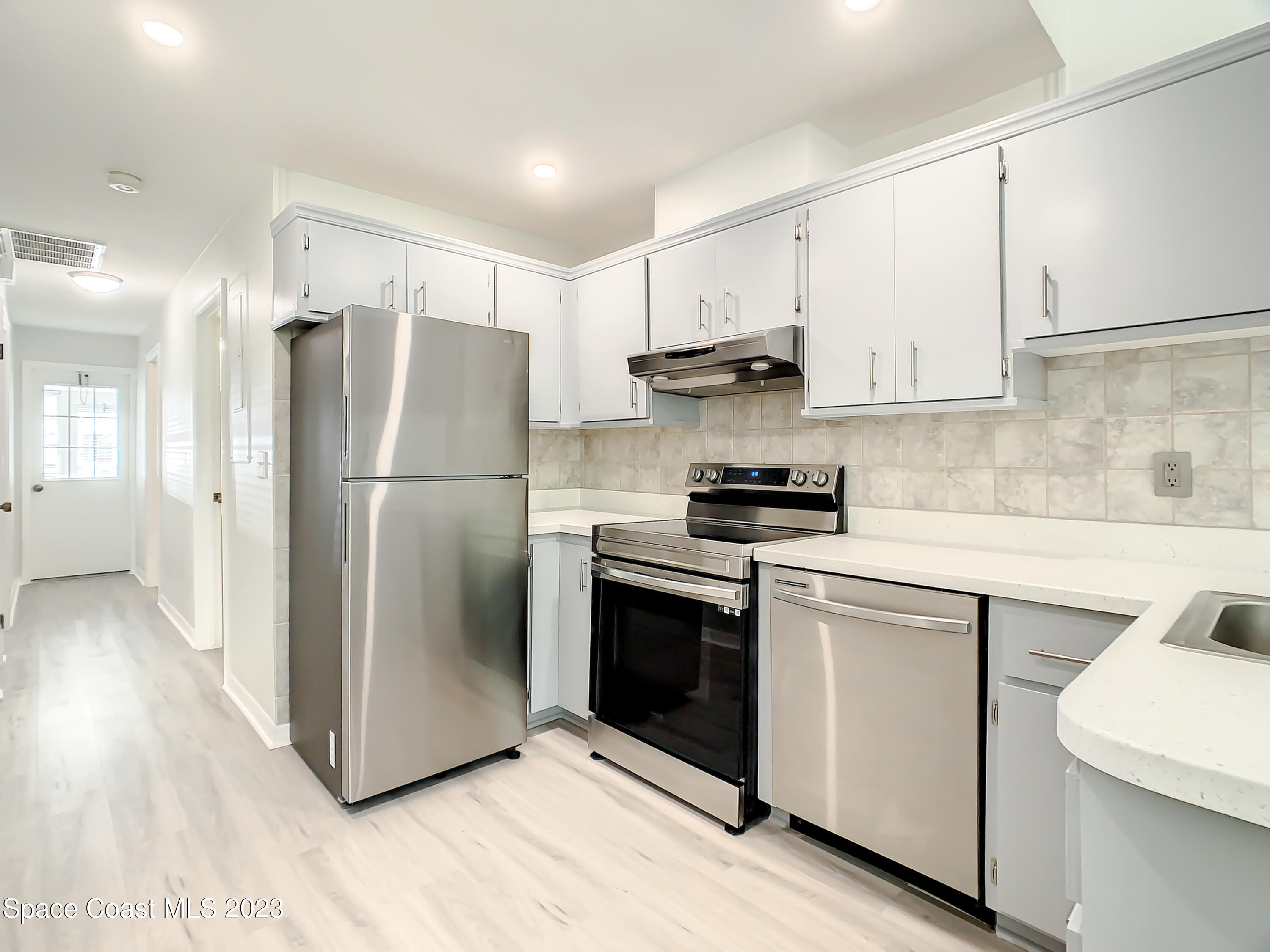 8520 Highway 1, Unit E9 Micco, FL 32976 - Photo 6 of 24 a kitchen with stainless steel appliances a refrigerator sink and cabinets