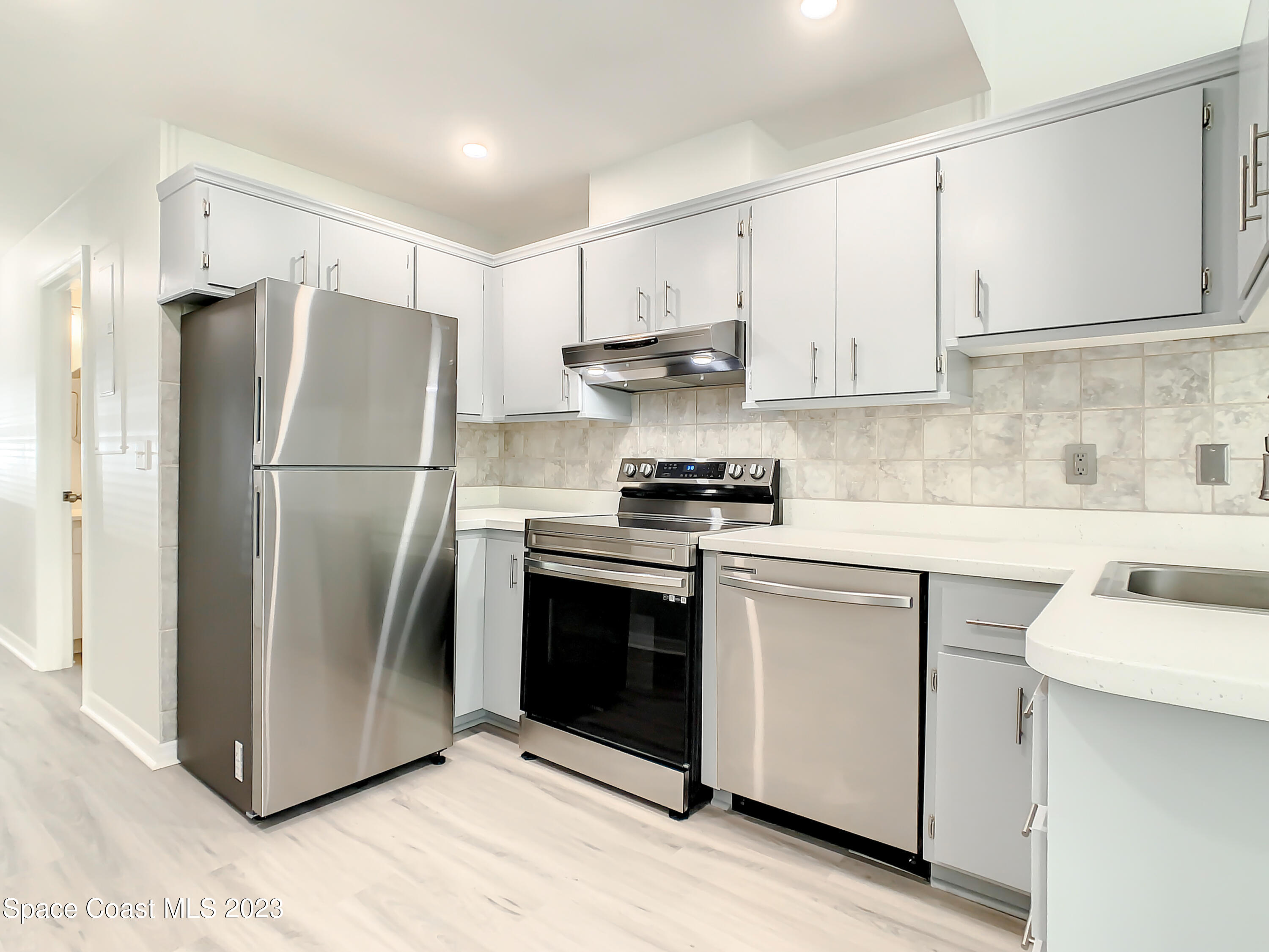 8520 Highway 1, Unit E9 Micco, FL 32976 - Photo 7 of 24 a kitchen with stainless steel appliances a refrigerator sink and cabinets