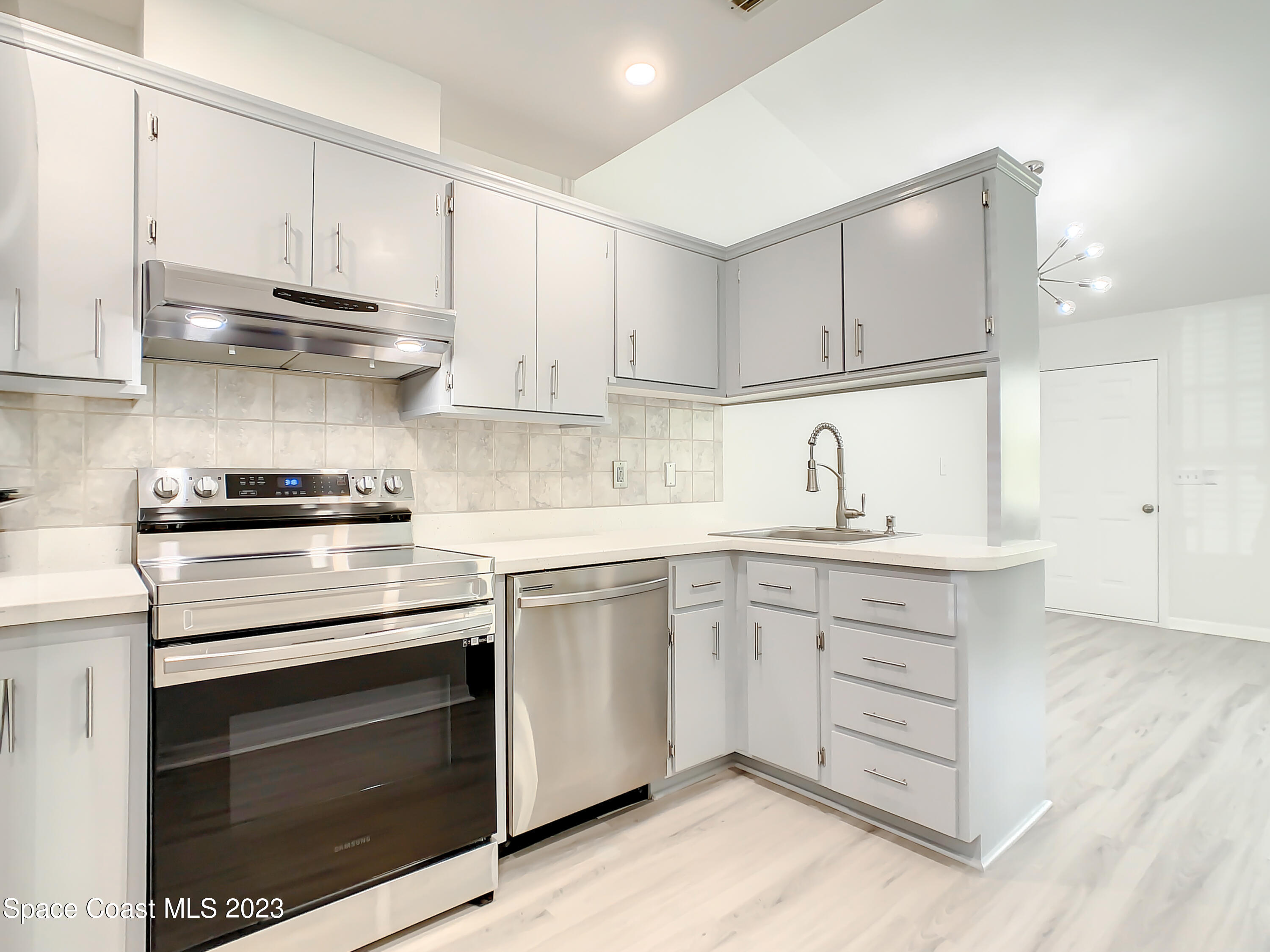 8520 Highway 1, Unit E9 Micco, FL 32976 - Photo 10 of 24 a kitchen with granite countertop white cabinets and white appliances