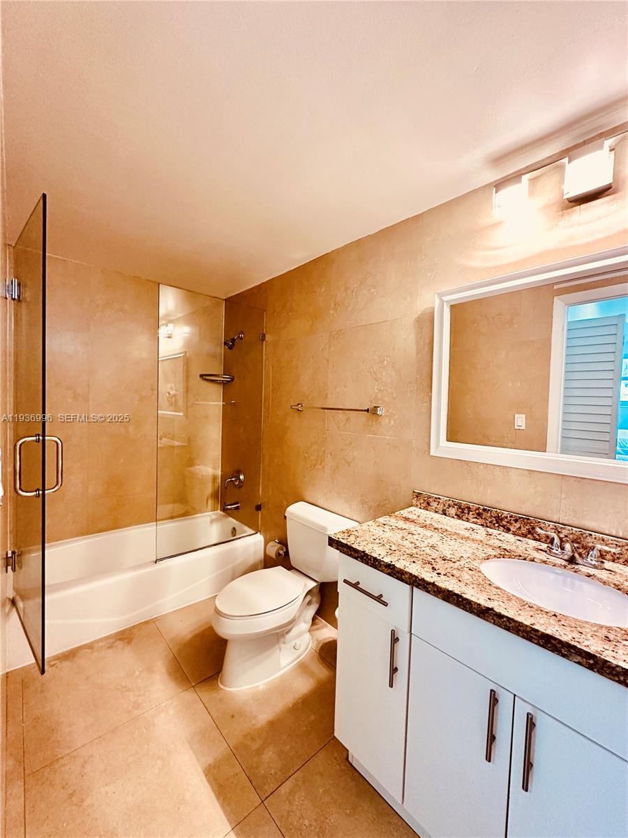 185 Southeast 14th Terrace, Unit 904 Miami, FL 33131 - Photo 11 of 19 a bathroom with a granite countertop sink toilet and shower