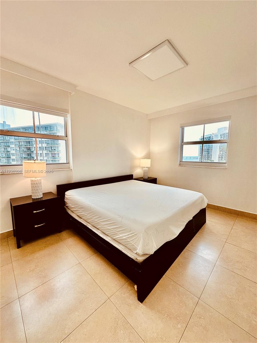 185 Southeast 14th Terrace, Unit 904 Miami, FL 33131 - Photo 12 of 19 a bedroom with a bed and a dresser next to a window