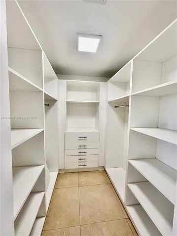 a view of walk in closet with empty racks