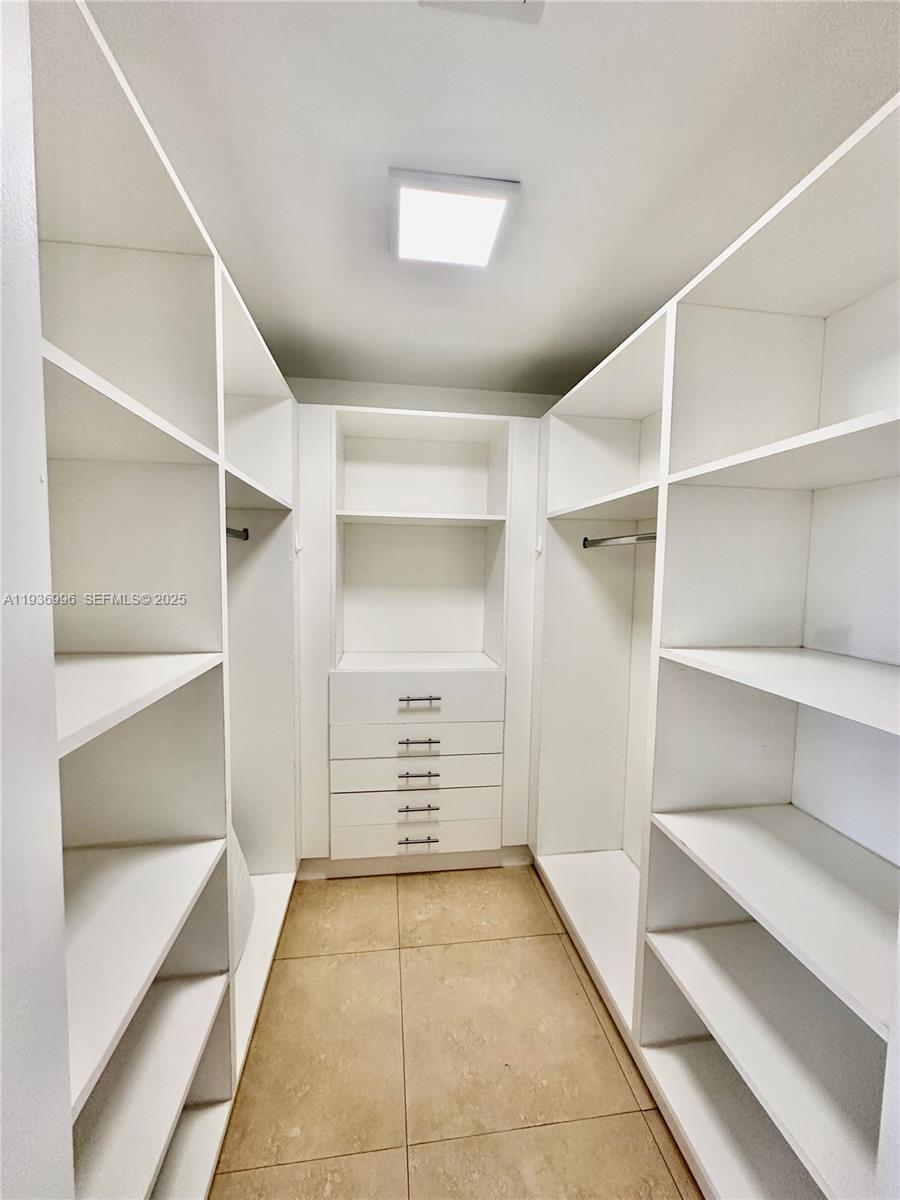 185 Southeast 14th Terrace, Unit 904 Miami, FL 33131 - Photo 14 of 19 a view of walk in closet with empty racks