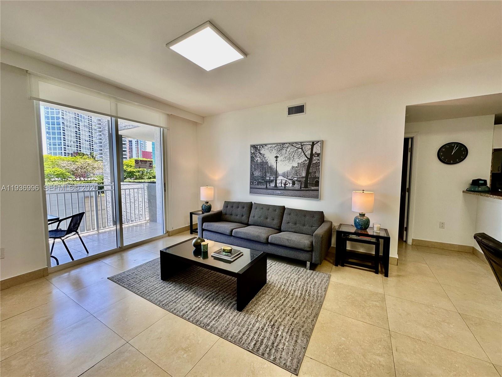 185 Southeast 14th Terrace, Unit 904 Miami, FL 33131 - Photo 6 of 19 a living room with furniture and wooden floor