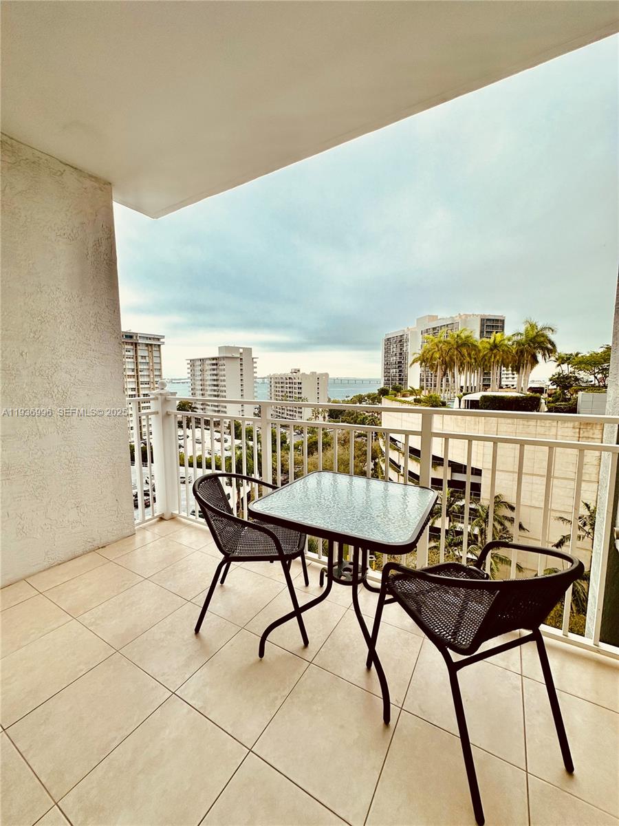 185 Southeast 14th Terrace, Unit 904 Miami, FL 33131 - Photo 7 of 19 a view of a chairs and table on the terrace