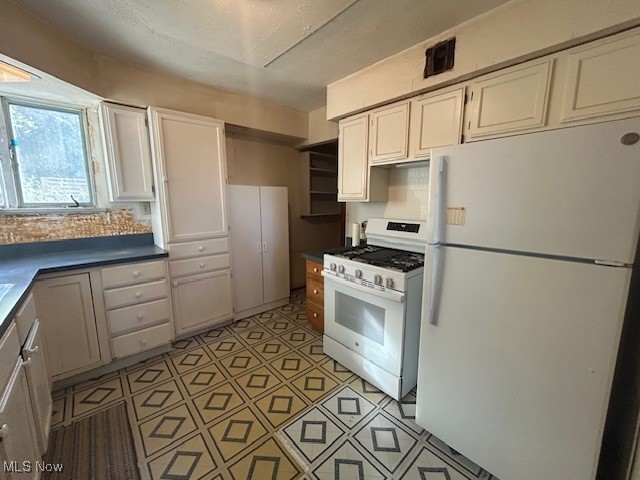 7987 Ridge Road North Royalton, OH 44133 - Photo 15 of 45 Kitchen with white appliances, dark countertops, and white cabinetry