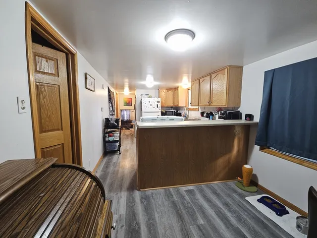 a kitchen with stainless steel appliances granite countertop a refrigerator a stove a sink and dishwasher with wooden floor