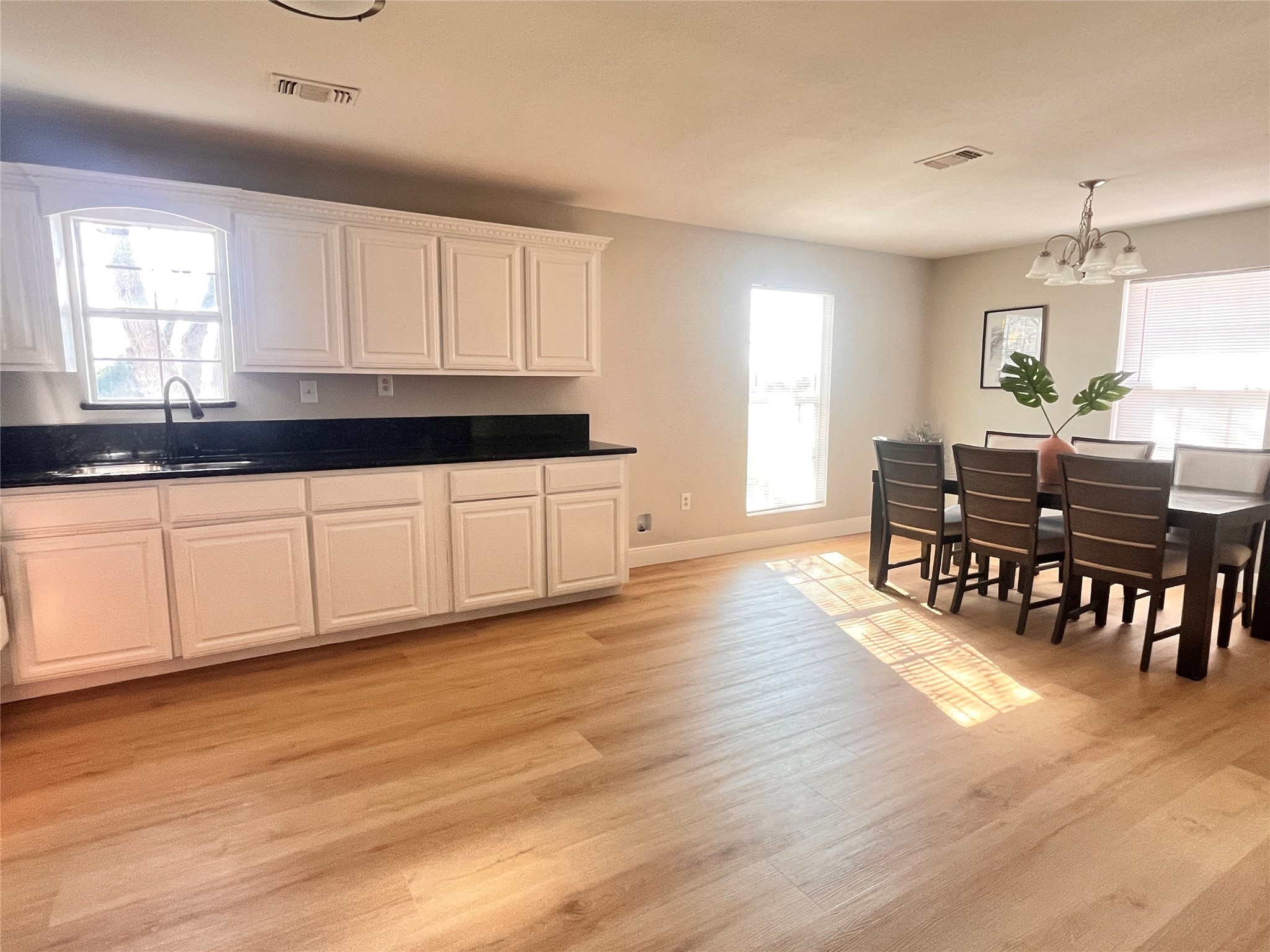 1010 Aurelia Lane Rosenberg, TX 77471 - Photo 11 of 29 a kitchen with granite countertop a stove a sink and white cabinets with wooden floor