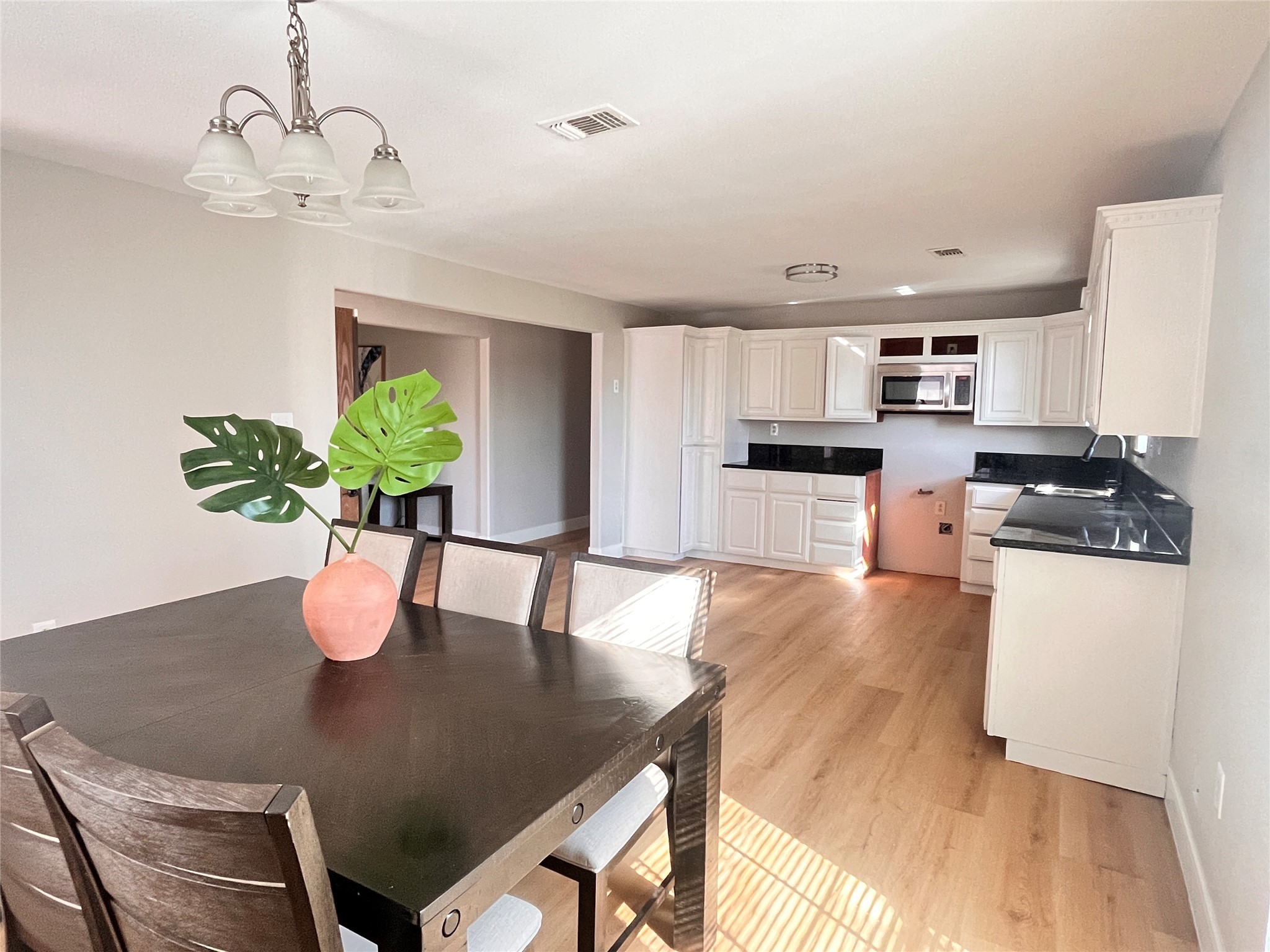 1010 Aurelia Lane Rosenberg, TX 77471 - Photo 13 of 29 a kitchen with stainless steel appliances granite countertop a stove a refrigerator a sink a dining table and chairs with wooden floor