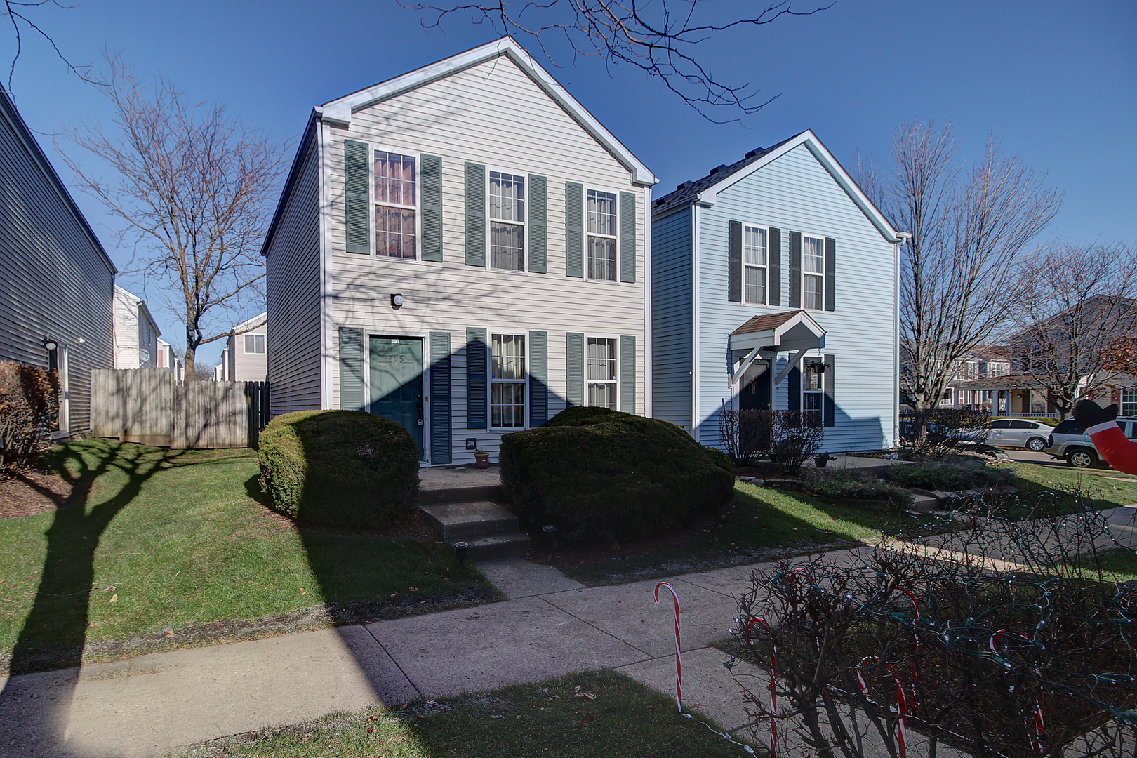 a front view of a house with garden and trees