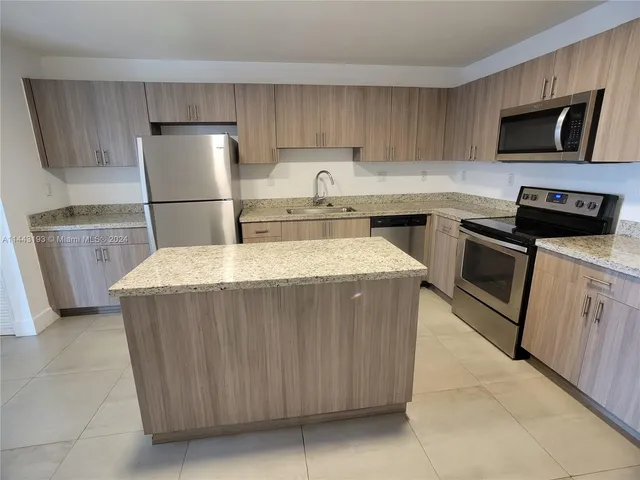 a kitchen with refrigerator and cabinets