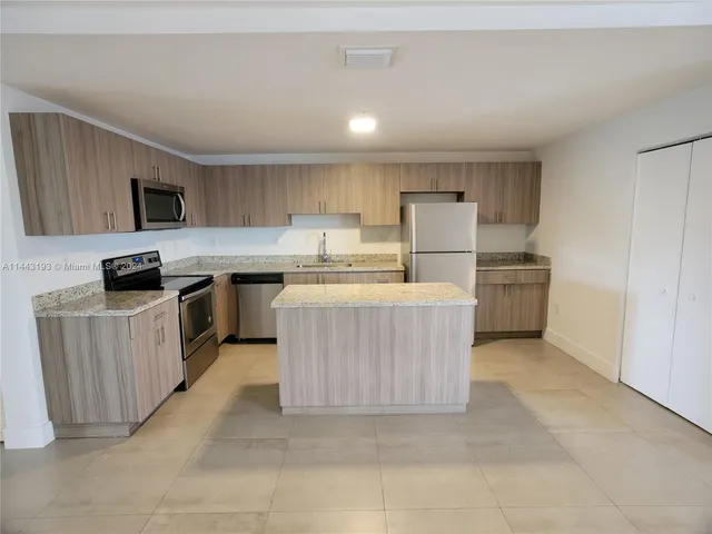 a view of kitchen with cabinets microwave and stove