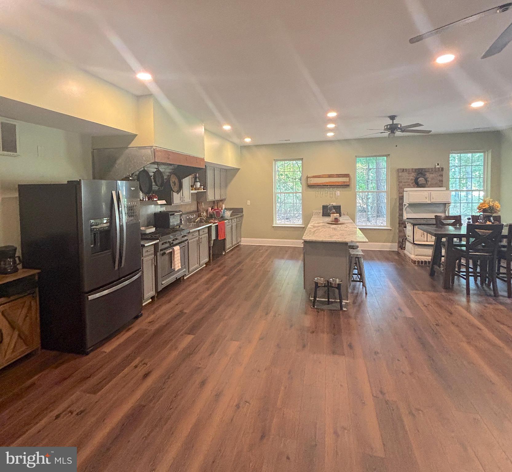 3138-3142 Moss Mill Road Hammonton, NJ 08037 - Photo 65 of 73 a kitchen with stainless steel appliances wooden floor dining table and chairs