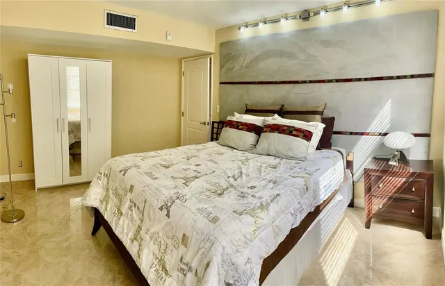 a bed sitting in a bedroom next to a bathroom