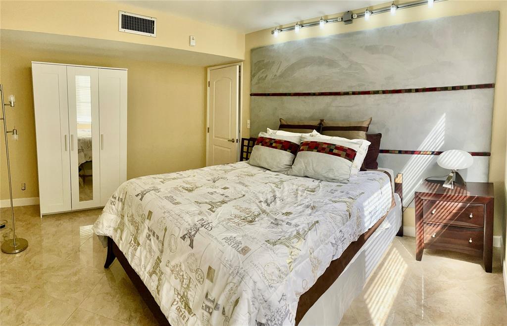 2681 South Course Drive, Unit 212 Pompano Beach, FL 33069 - Photo 12 of 16 a bed sitting in a bedroom next to a bathroom