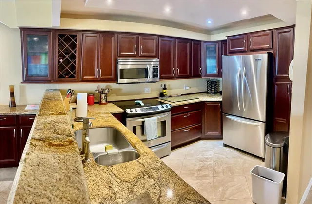a kitchen with wooden cabinets and stainless steel appliances