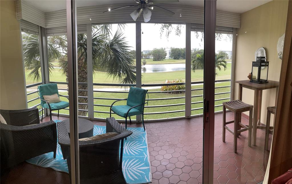 2681 South Course Drive, Unit 212 Pompano Beach, FL 33069 - Photo 6 of 16 a porch with a bench next to a yard