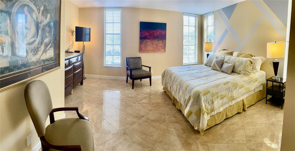 2681 South Course Drive, Unit 212 Pompano Beach, FL 33069 - Photo 10 of 16 a bed room with a bed and a chair