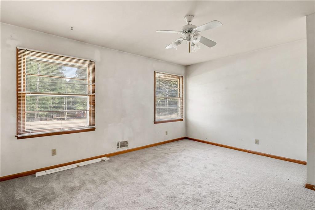 1315 Fairview Road Ellenwood, GA 30294 - Photo 15 of 34 an empty room with chandelier fan and windows