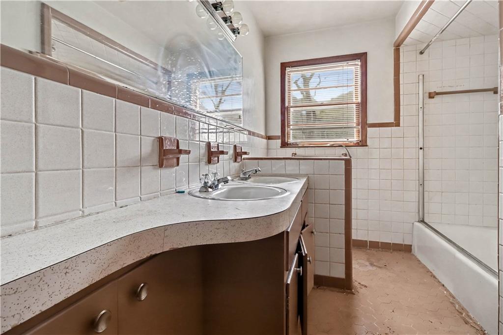 1315 Fairview Road Ellenwood, GA 30294 - Photo 24 of 34 a bathroom with a sink a mirror and a bathtub