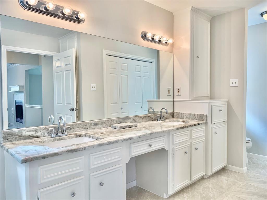 a bathroom with a granite countertop sink double and mirror