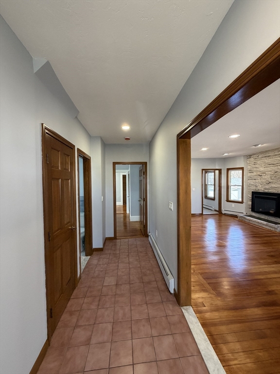 117 Merrymount Road, Unit 1 Quincy, MA 02169 - Photo 10 of 12 a view of a hallway with wooden floor and a fireplace