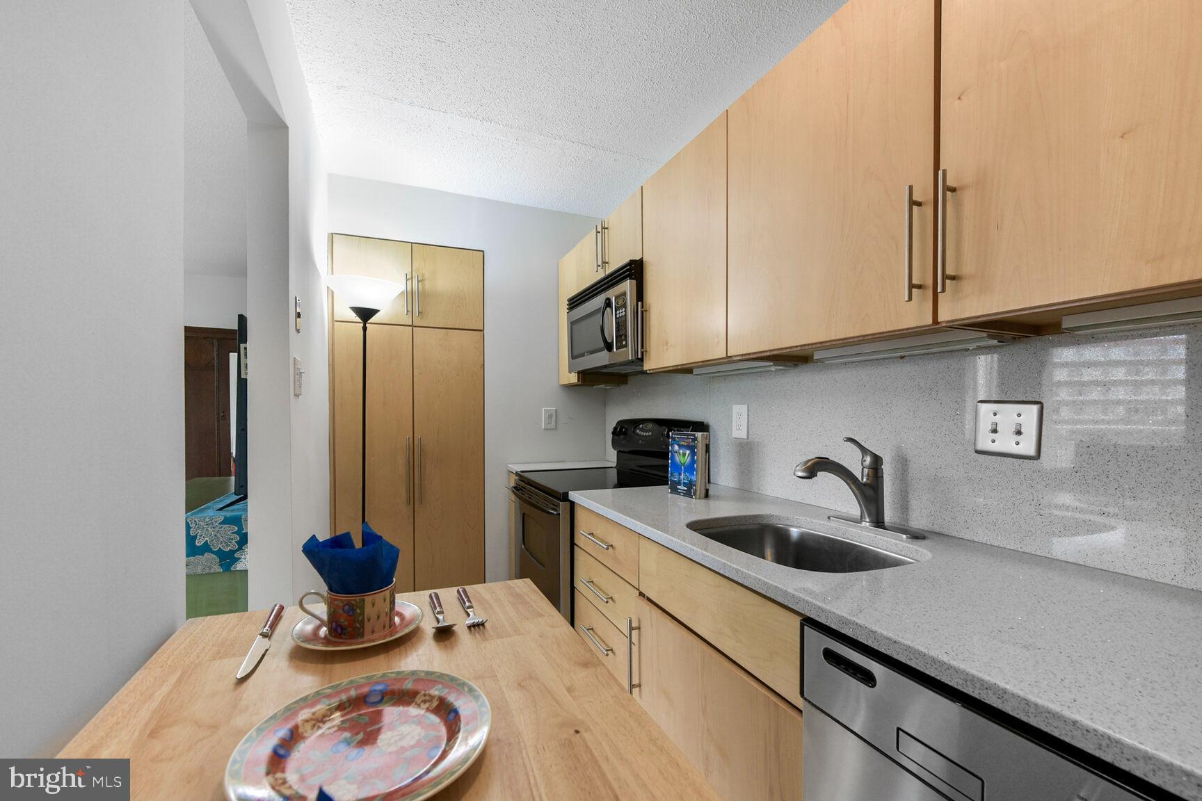1301 South Arlington Ridge Road, Unit 404 Arlington, VA 22202 - Photo 10 of 43 a kitchen with stainless steel appliances granite countertop a sink a stove and cabinets