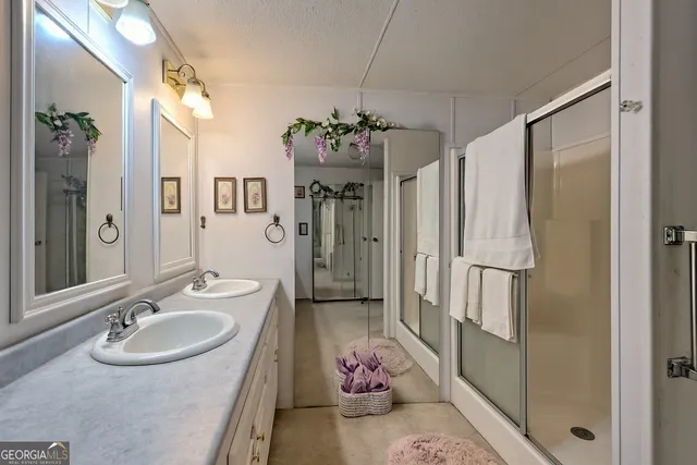 a spacious bathroom with a sink double shower and a mirror
