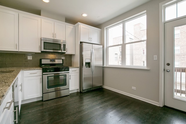 2314 East 71st Street, Unit B Chicago, IL 60649 - Photo 5 of 19 a kitchen with stainless steel appliances a stove a sink and a window