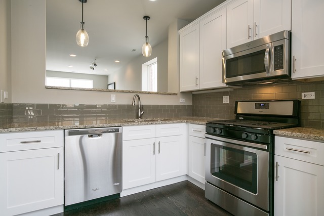 2314 East 71st Street, Unit B Chicago, IL 60649 - Photo 6 of 19 a kitchen with stainless steel appliances granite countertop a stove a sink and a microwave