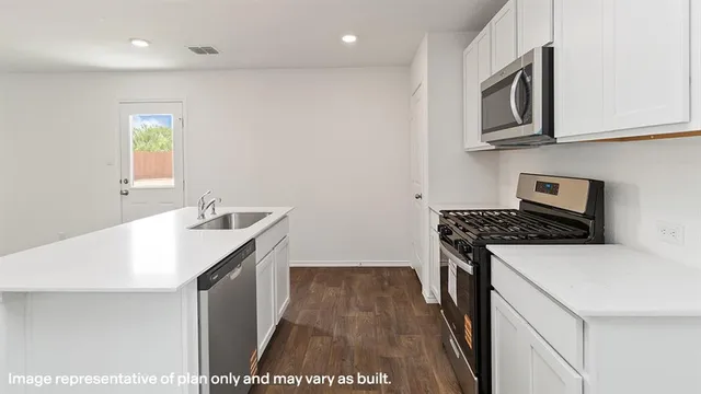 a utility room with cabinets washer and dryer