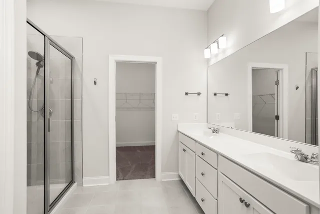 a spacious bathroom with a double vanity sink a mirror and a shower