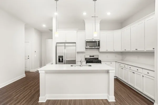 a kitchen with kitchen island a sink stainless steel appliances and white cabinets