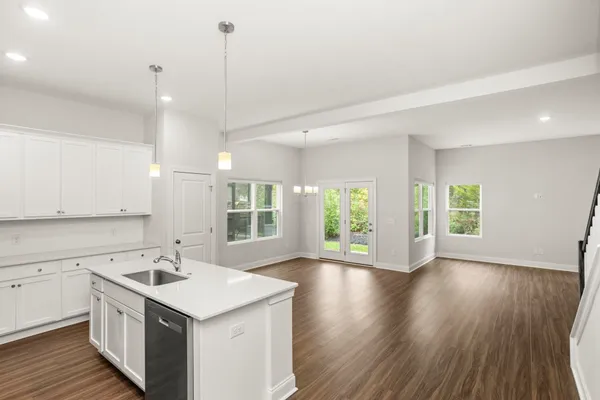 a kitchen with a sink a window and wooden floor