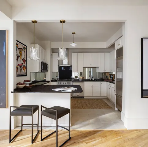 a kitchen with kitchen island granite countertop a sink cabinets and stainless steel appliances