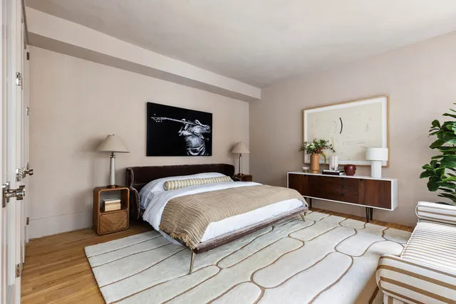 a bedroom with a bed and a painting on the wall