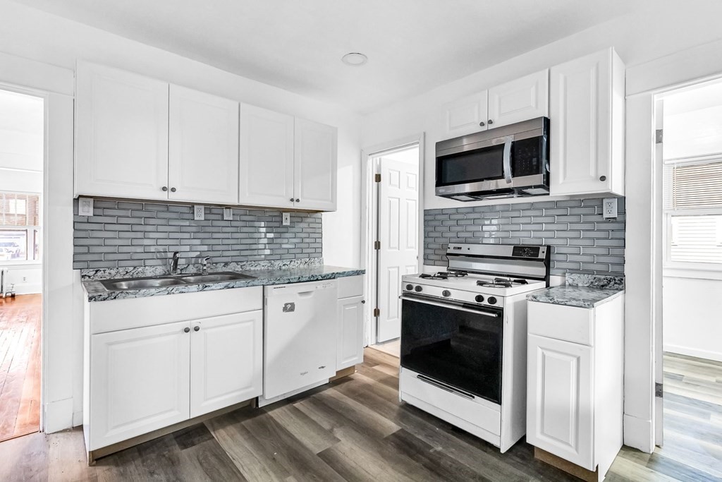 a kitchen with white cabinets stainless steel appliances and sink