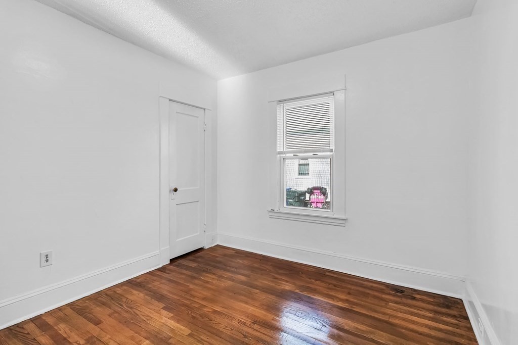 55 Redlands Street Springfield, MA 01104 - Photo 13 of 42 an empty room with wooden floor and windows