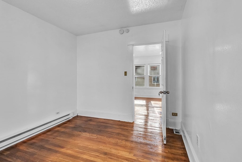 55 Redlands Street Springfield, MA 01104 - Photo 15 of 42 a view of an empty room with wooden floor and a window
