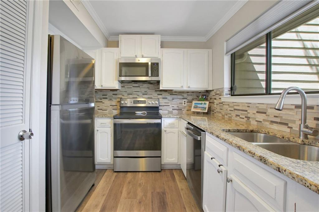 1929 Variations Drive Northeast Atlanta, GA 30329 - Photo 14 of 33 a kitchen with stainless steel appliances granite countertop a sink a stove a refrigerator and cabinets