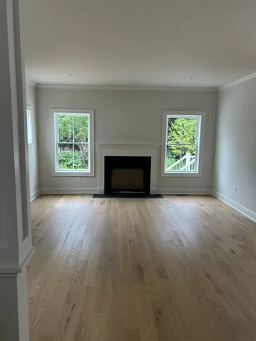an empty room with windows and fireplace