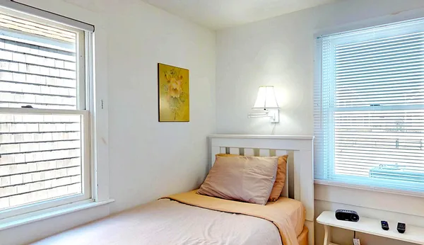 a bedroom with a bed and a flat tv screen on the dresser