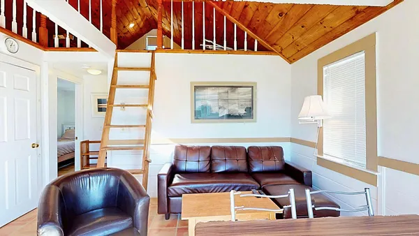 a view of a bedroom with a bed and large windows