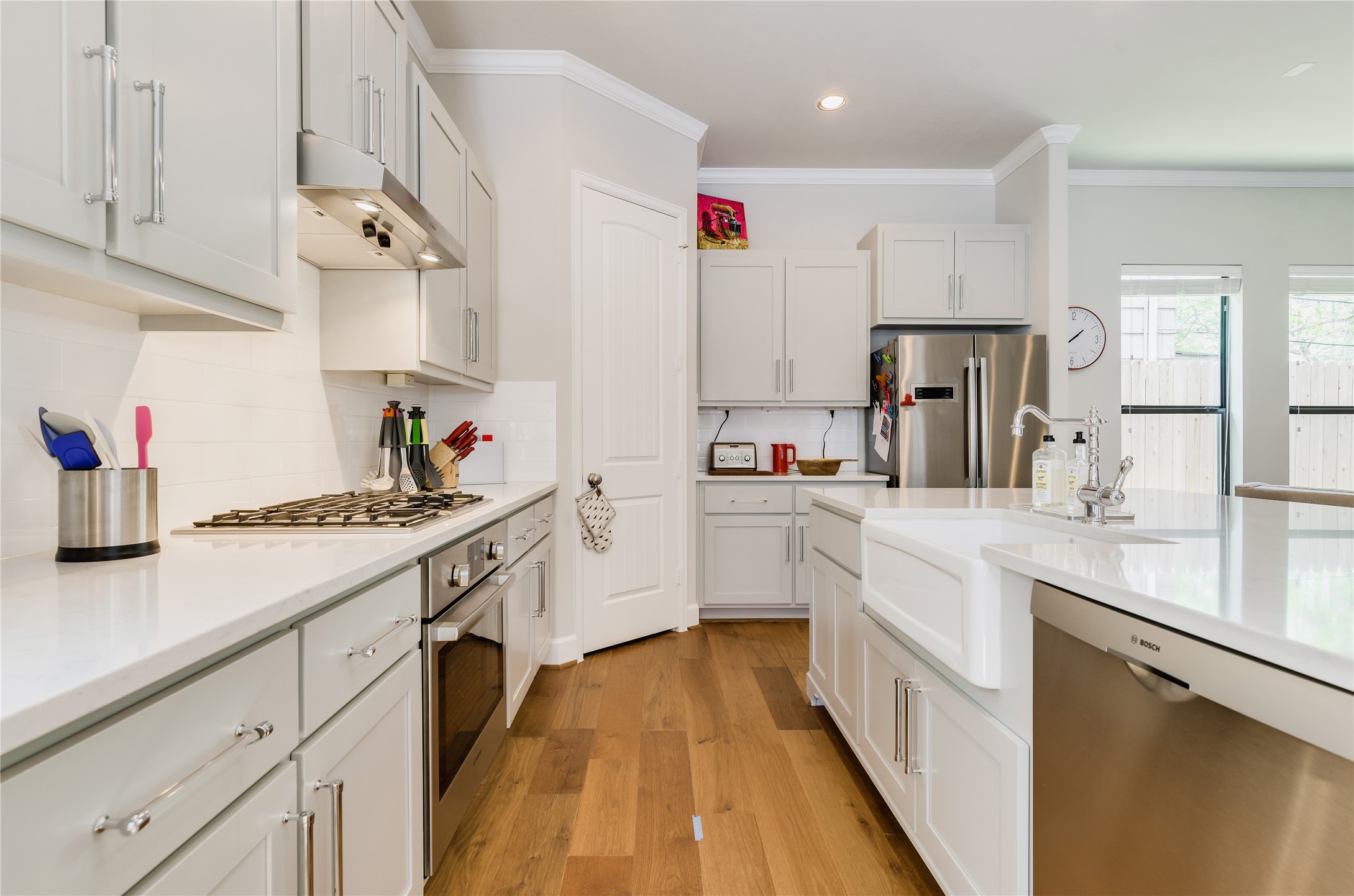 4014 Woodhead Street Houston, TX 77098 - Photo 12 of 37 a kitchen with kitchen island white cabinets and white appliances